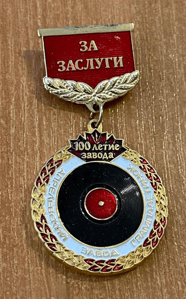 Памятный нагрудной знак "ЗА ЗАСЛУГИ. 100 летие завода. АПРЕЛЕВСКИЙ ЗАВОД ГРАМПЛАСТИНОК"